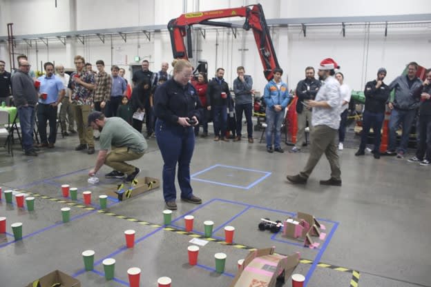 Weir Group engineers drive RC cars through a maze outlined by paper cups. The track simulates navigating hazards like mine bridges. Image: Weir Group